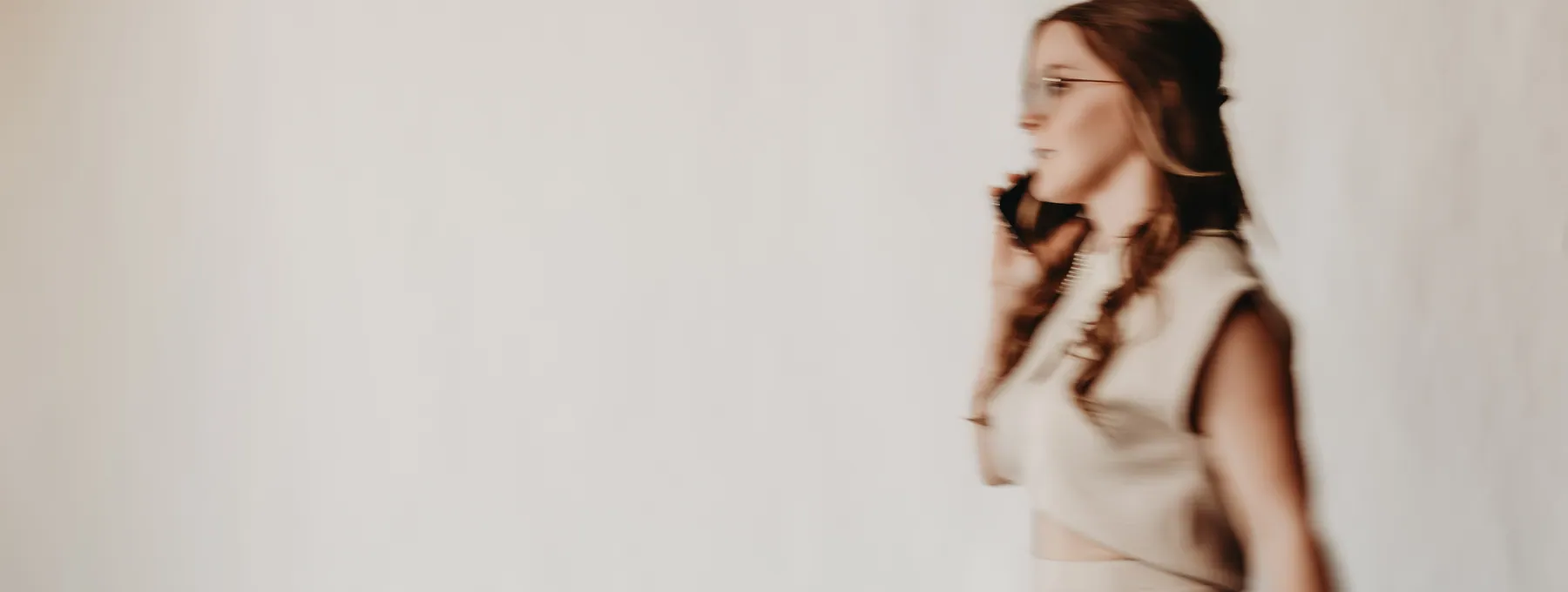 Andrea Wade walking, mid-motion, carrying a leather bag