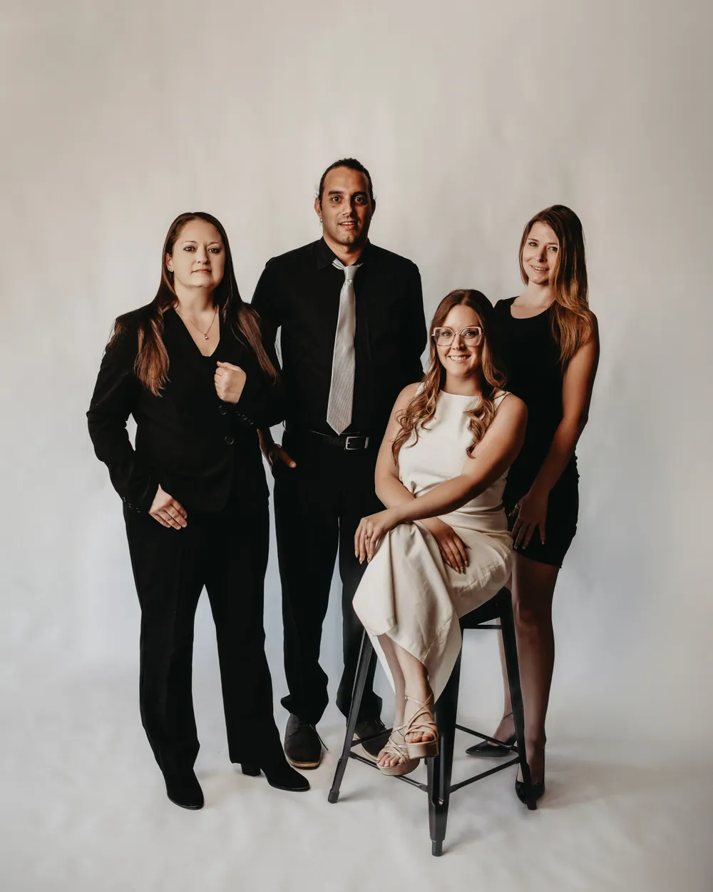 The Estate Collective team, standing together in formal dress against a light backdrop
