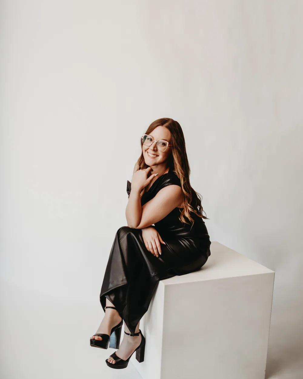 Andrea Wade, seated in a black dress against a light backdrop